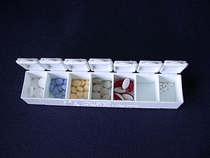 A pill box with various medications in it.